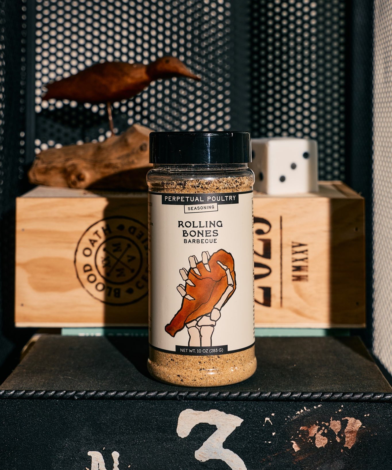 A bottle of Rolling Bones BBQ Perpetual Poultry dry rub seasoning.