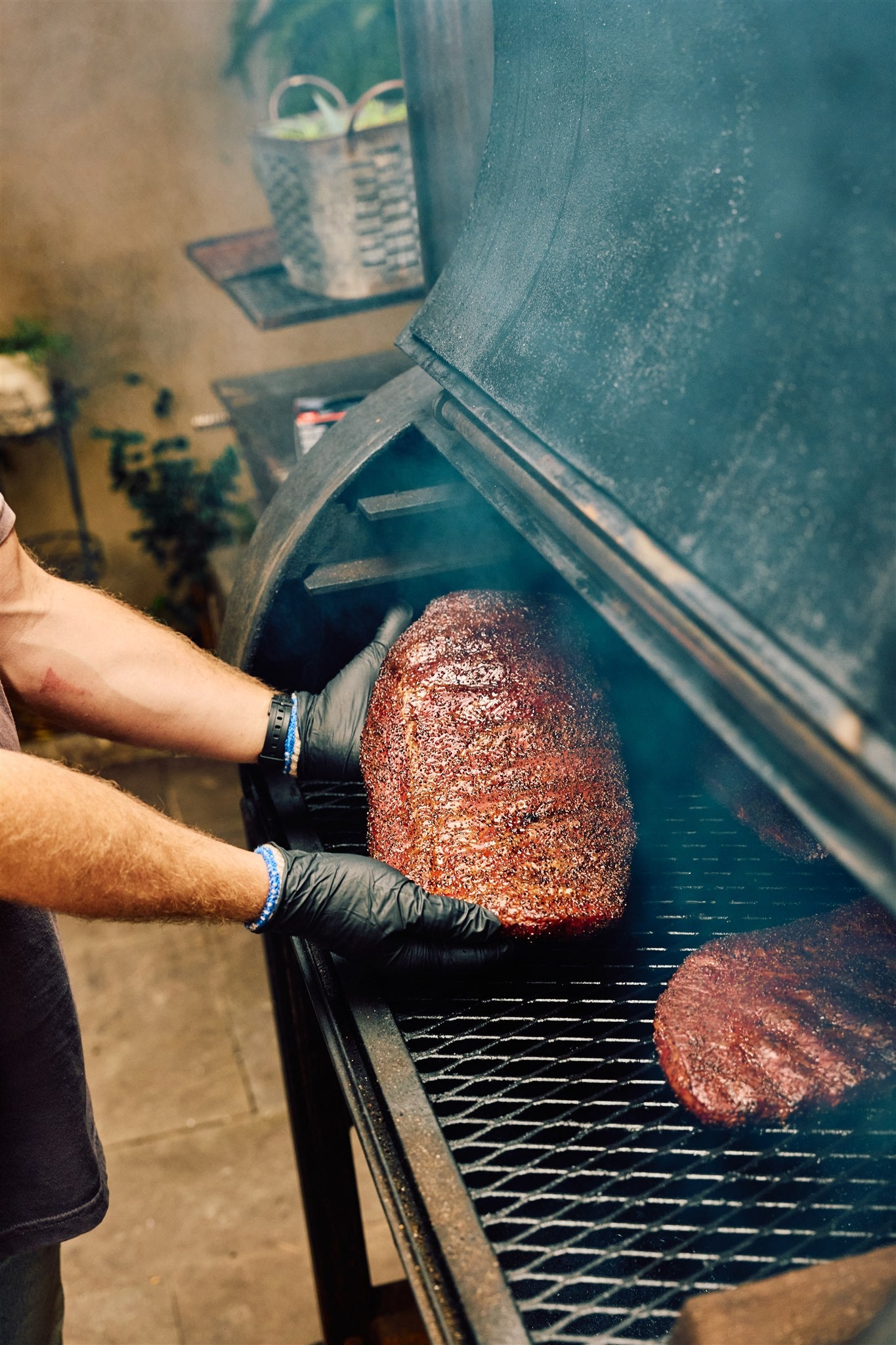 Will from Rolling Bones BBQ grilling meat on a barbecue grill outdoors and showing off a perfectly smoked rack of ribs.