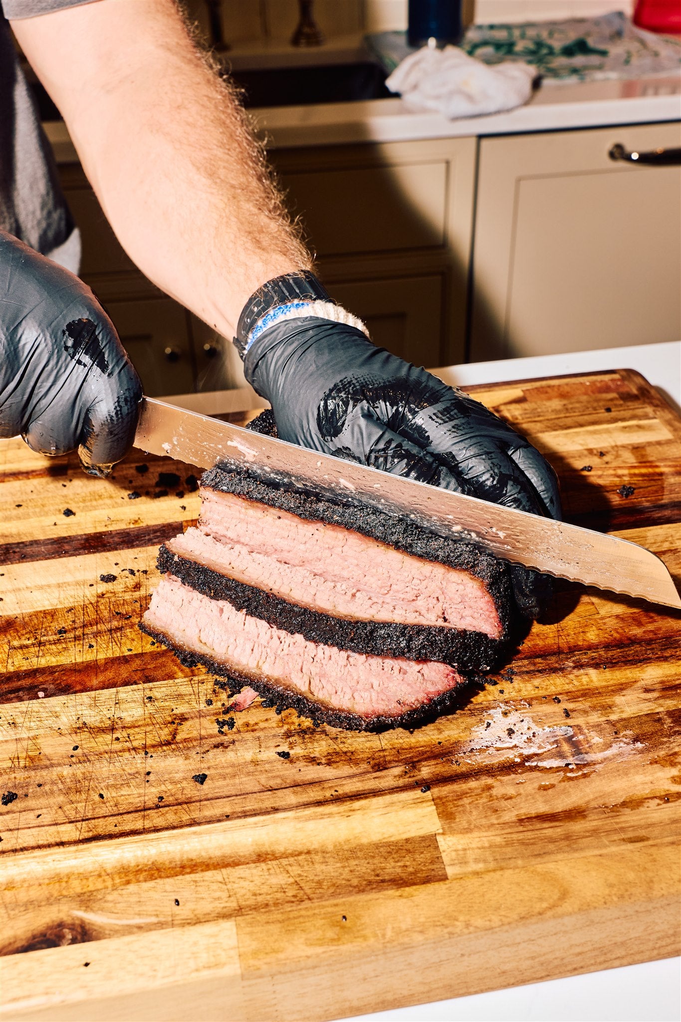 Bottle of Rolling Bones BBQ Perpetual Beef dry rub seasoning forming the bark on a sliced brisket.