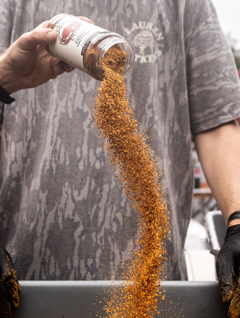 Person pouring a brown substance from a container into a tray